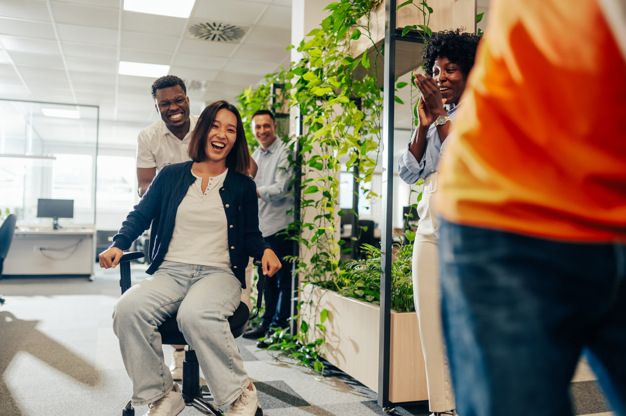 Colleagues laughing together in a plant-filled office at Breath of Life